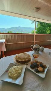 een tafel met twee borden eten en een taart bij Beekeeper's Hause in Arslanbob