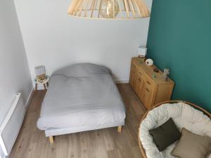 ein kleines Schlafzimmer mit einem Bett und einem Stuhl in der Unterkunft Scandinave - proche gare & centre-ville - stationnement - cour intérieure table & chaises in Saint-Brieuc