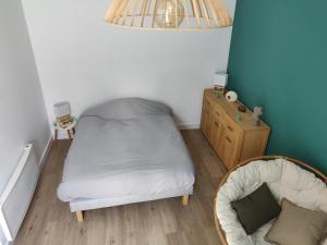 a small bedroom with a bed and a chair at Scandinave - proche gare & centre-ville - stationnement - cour intérieure table & chaises in Saint-Brieuc