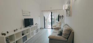 a living room with two couches and a tv at CASA IVE ROMANTIC POOL in Caleta De Fuste