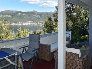 eine Veranda mit einem Tisch und Stühlen sowie Blick auf das Wasser in der Unterkunft Holiday home SANDANE II in Sandane