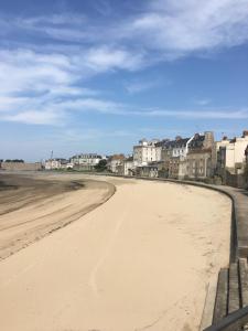 an empty beach with houses in the background at Cocon d'Emeraude Saint-Malo in Saint Malo
