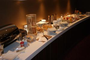 a buffet table with plates and food on it at Hôtel François Premier Cognac Centre in Cognac