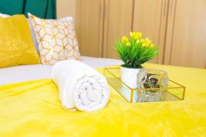 a towel and a vase of flowers on a table at The Ivy Suite- one bedroom 3 mins away from Ruiru Rainbow Resort in Ruiru