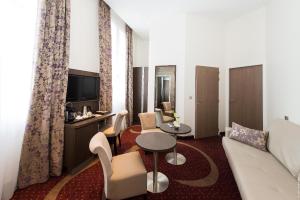 a living room with a couch and a table at Hôtel François Premier Cognac Centre in Cognac
