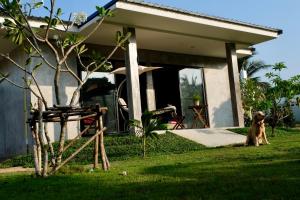 a dog sitting in front of a house at PHUKET THALANG POOL VILLA in Thalang