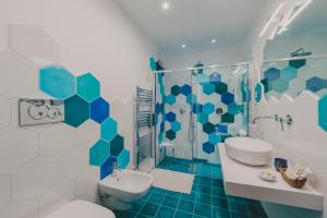 a blue and white bathroom with a toilet and a shower at Villa Nettuno in Positano