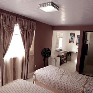 a bedroom with two beds and a window at Isa Natal 3 Banheiro Privativo in Natal +7 photos