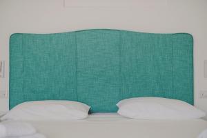 a green headboard with two pillows on a bed at Villa Nettuno in Positano