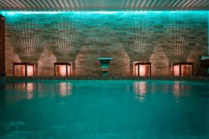 an indoor swimming pool with a brick wall and a swimming pool at Hôtel François Premier Cognac Centre in Cognac