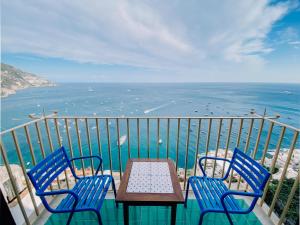 two chairs and a table on a balcony with the ocean at Villa Nettuno in Positano