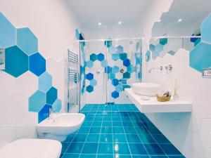 a blue and white bathroom with two sinks and a shower at Villa Nettuno in Positano +30 photos