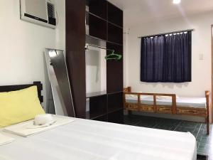 a room with a bed and a bedroom with a window at Chill Out Hostel in Boracay