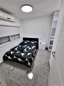 een slaapkamer met een zwart-wit dekbed op een bed bij Diamond Suites Eilat in Eilat