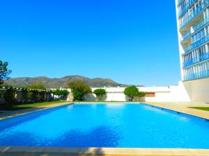 una gran piscina azul junto a un edificio en GMID IMMO Estudio Ed La Masia, en Roses