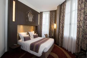 a hotel room with a bed and a large window at Hôtel François Premier Cognac Centre in Cognac