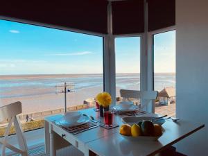 a dining room with a table with a view of the beach at TYME Coastal Retreats - 1 and 2 Bedroom in Cleethorpes
