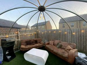 ein Wohnzimmer mit 2 Sofas in einem Zelt in der Unterkunft ☆Igloo MagnoliaView Luxe Townhouse + Free Parking☆ in Leeds