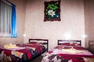 2 camas en un dormitorio con una foto en la pared en Villa Riens Dream, en Karangasem