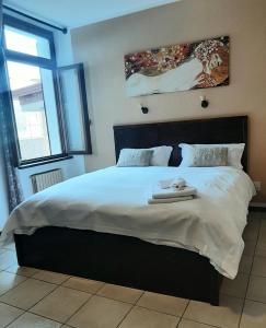- une chambre avec un grand lit et 2 serviettes dans l'établissement Camere Porto Vecchio con parcheggio a pochi passi dal castello, à Malcesine