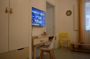 Habitación con escritorio y TV en la pared. en Arco Cutò casa vacanze, en Palermo
