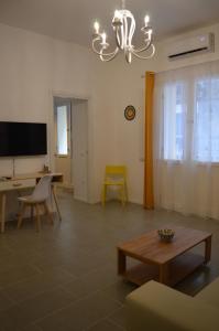 a living room with a table and a chandelier at Arco Cutò casa vacanze in Palermo