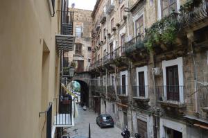 un vicolo con edifici e un'auto parcheggiata in una strada di Arco Cutò casa vacanze a Palermo