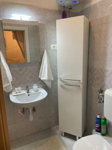 y baño con nevera blanca y lavamanos. en Rooms Zana en Split