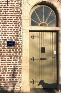 a door on a brick building with a sign on it at Gîte La Cure in Noduwez