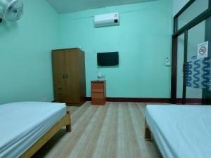 Zimmer mit 2 Betten und einem TV an der Wand in der Unterkunft JaiSabai Homestay in Mae Ai