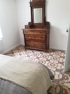 a bedroom with a dresser and a mirror at Parfum de liberté in Le Bosc