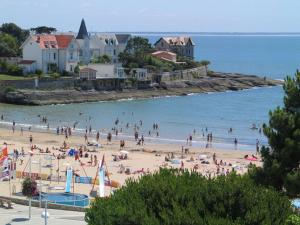 Un grupo de personas en una playa en el agua. en T2 au centre de Saint-Palais-Sur-Mer, en Saint-Palais-sur-Mer