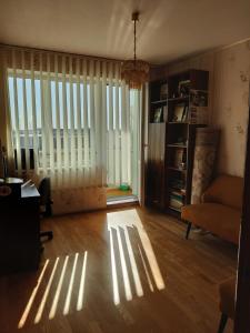 a living room with sunlight streaming through the windows at Prie Masčio ežero in Telšiai