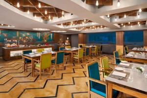 un restaurante con mesas y sillas y un bar en Howard Johnson by Wyndham Udaipur Roop Nagar, en Udaipur