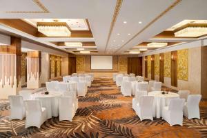 ein Bankettsaal mit weißen Tischen und weißen Stühlen in der Unterkunft Howard Johnson by Wyndham Udaipur Roop Nagar in Udaipur + 37 Fotos