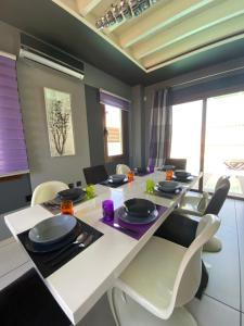een eetkamer met een witte tafel en stoelen bij Purple Villa in Paralimni