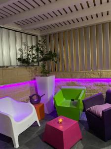 a patio with colorful furniture and purple lights at Purple Villa in Paralimni