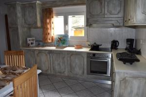 a kitchen with wooden cabinets and a stove top oven at Kerasia's and Dora's garden in Punta