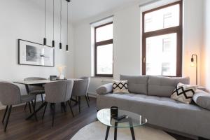 - un salon avec un canapé et une table dans l'établissement Bheaven I Jugendstil Premium Apartment, à Bremerhaven