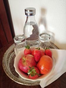 een bord aardbeien en een fles water bij Casa dos Pingos de Mel in Aveiro