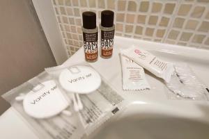 a bathroom sink with two bottles of mouthwash and toothpaste at Hotel Poetto in Cagliari