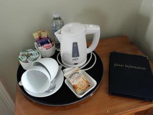 a coffee maker on a plate on a table at Breakers Bed and Breakfast in Eastbourne