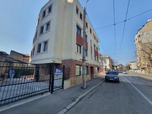 a car parked in front of a building on a street at Dacia Residence Apartments in Bucharest