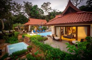 a villa with a swimming pool next to a house at Dream Villa Double Bay Sunset on Andaman Sea in Kata Beach