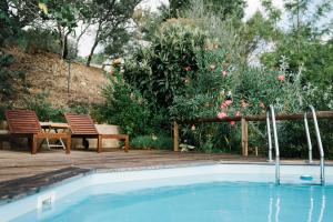 a swimming pool with two chairs and a table at Quinta do Arade - Casa Girassol in Silves