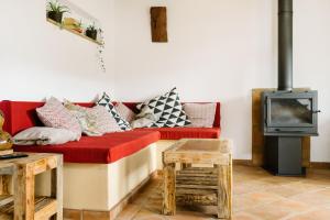 a living room with a red couch and a tv at Quinta do Arade - Casa Girassol in Silves