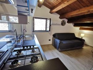 een keuken met een fornuis en een bank in een kamer bij SIeSI in Piedimonte Etneo