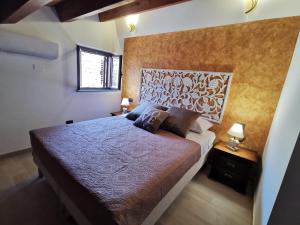 een slaapkamer met een groot bed en 2 lampen bij SIeSI in Piedimonte Etneo