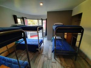 Aji Hostel في سانتياغو: غرفة بها ثلاثة أسرة بطابقين