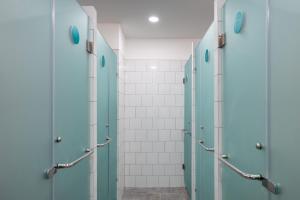 uma casa de banho com portas azuis e azulejos brancos em Bobopod Kebayoran Baru, Jakarta em Jacarta